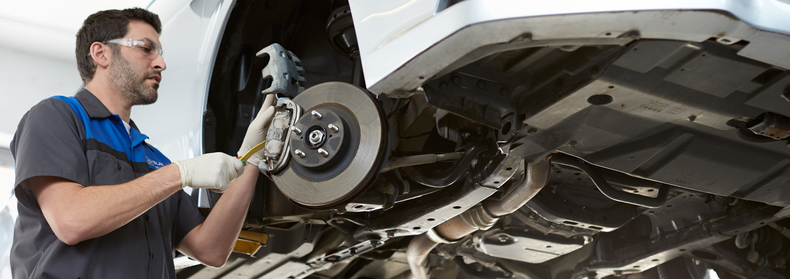 Subaru technician working on a Subaru brake caliper.